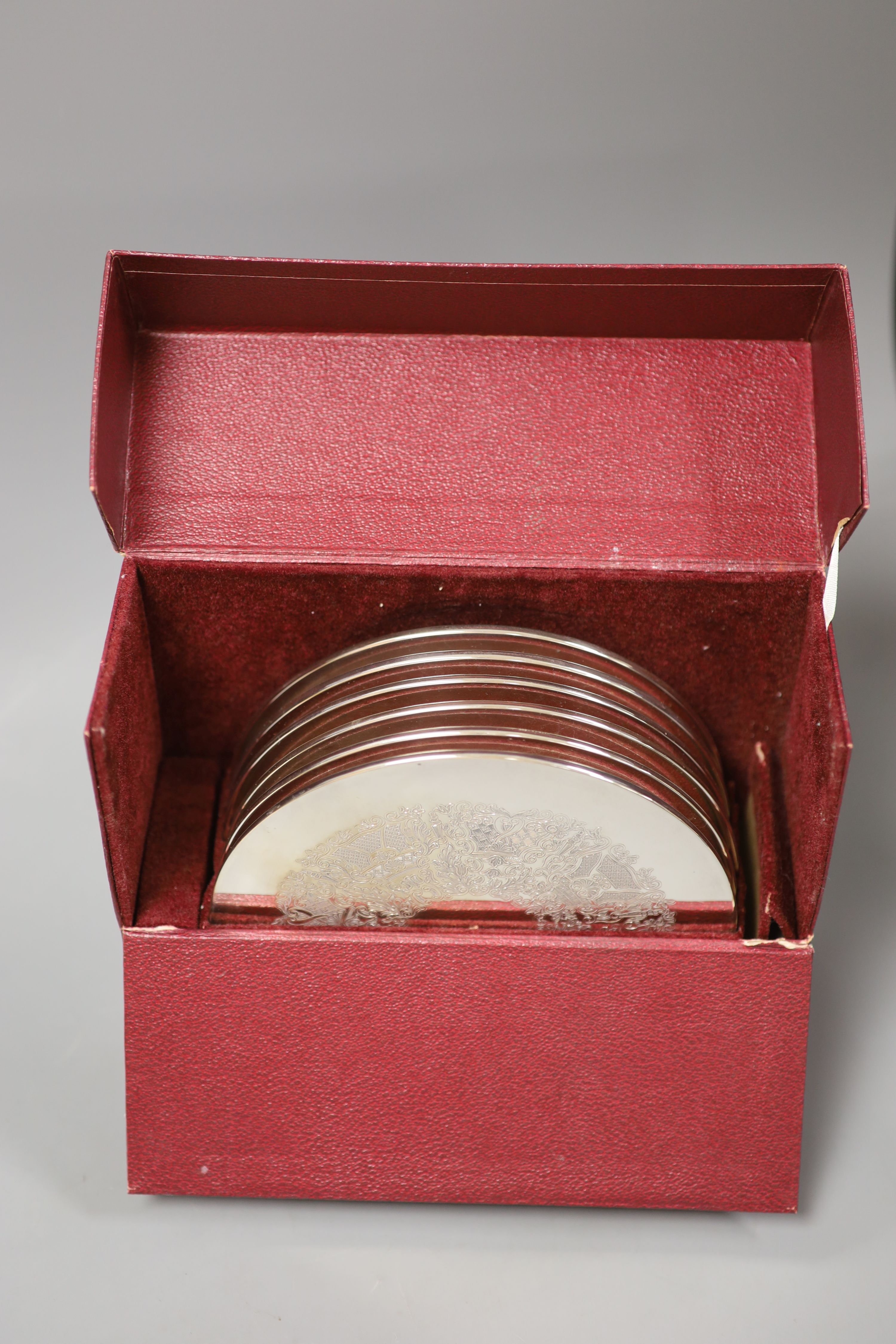 A set of six circular silver-mounted table mats